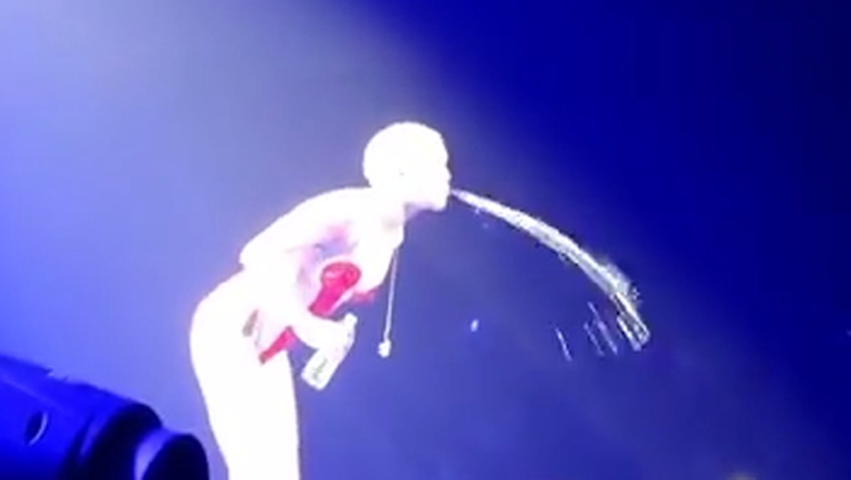 Miley samlar saliv och vatten och spottar. 